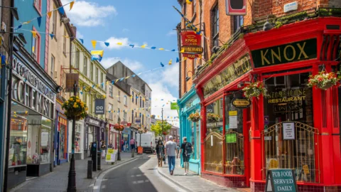 Colourful, vibrant street in a charming Irish town with pubs and shops, perfect for exploring and enjoying local culture.